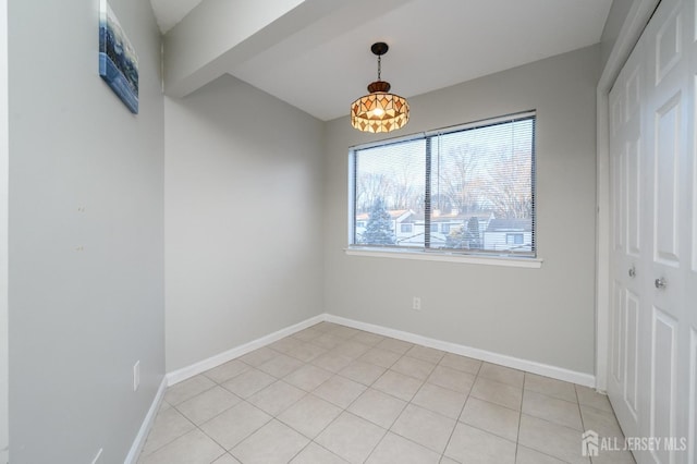 empty room with light tile patterned flooring and baseboards