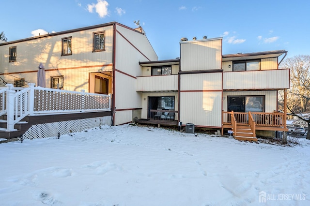 snow covered house featuring a deck