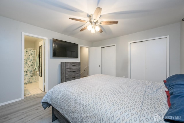 bedroom featuring light wood finished floors, two closets, a ceiling fan, and connected bathroom