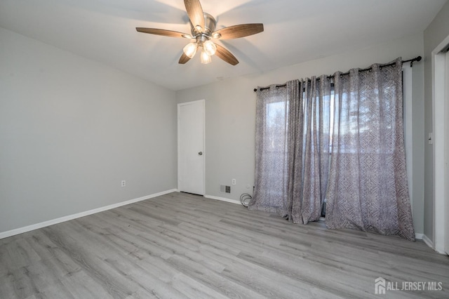 unfurnished room featuring a ceiling fan, baseboards, and wood finished floors