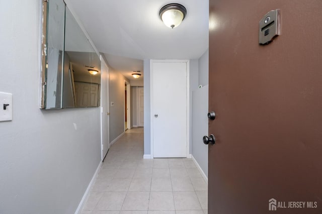 hall with light tile patterned floors and baseboards