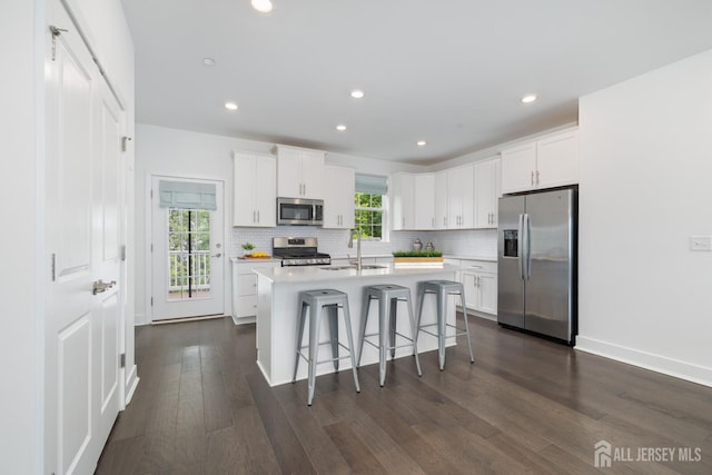 1617 Swales Ct, Monroe, NJ 08831 - kitchen with stainless steel appliances, a kitchen bar, dark wood finished floors, tasteful backsplash, and light countertops
