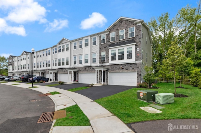 1617 Swales Ct, Monroe, NJ 08831 - townhome / multi-family property featuring stone siding, a garage, and driveway