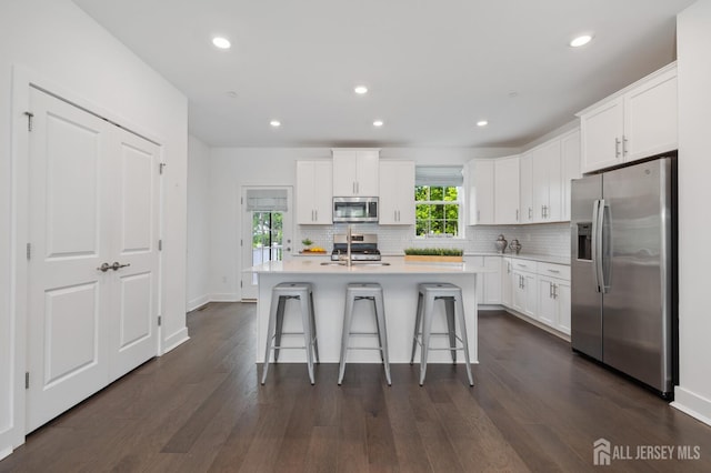 1617 Swales Ct, Monroe, NJ 08831 - kitchen featuring appliances with stainless steel finishes, a kitchen breakfast bar, tasteful backsplash, dark wood-style floors, and recessed lighting