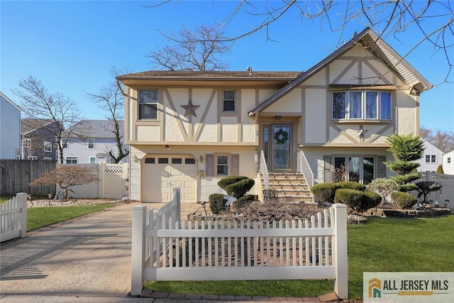 tudor home with a front yard and a garage