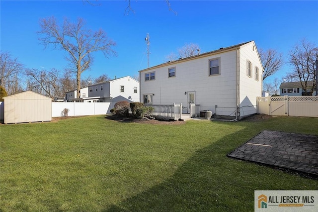 back of property with a storage shed, a yard, and central air condition unit