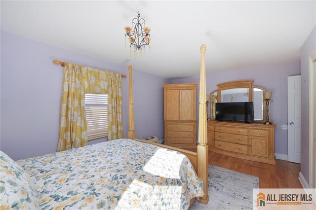 bedroom featuring light wood-type flooring and a notable chandelier