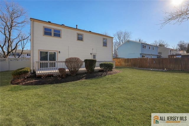 rear view of house featuring a yard and a deck