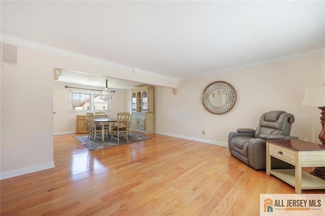 living room with crown molding and light wood-type flooring