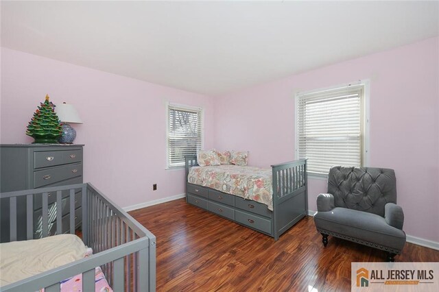 bedroom with dark hardwood / wood-style floors