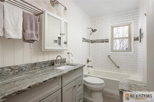 full bathroom featuring tiled shower / bath, toilet, vanity, and wood-type flooring