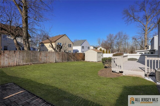 view of yard featuring a storage unit and a wooden deck