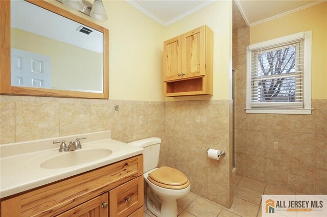 bathroom with tile walls, tile patterned flooring, ornamental molding, and toilet