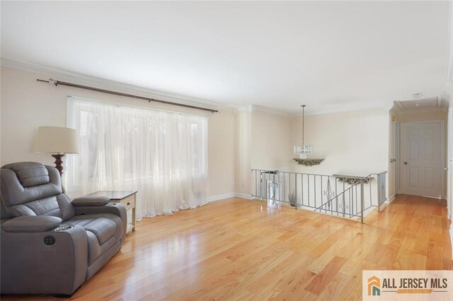 sitting room with ornamental molding and hardwood / wood-style floors