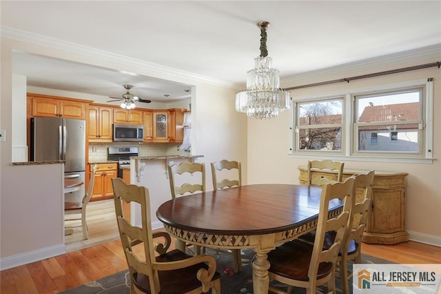 dining area with ceiling fan with notable chandelier, light wood-type flooring, and crown molding