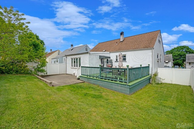 back of property featuring a yard, a deck, and a patio area