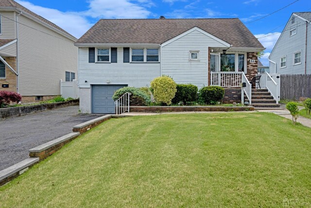 view of front of property featuring a garage and a front lawn