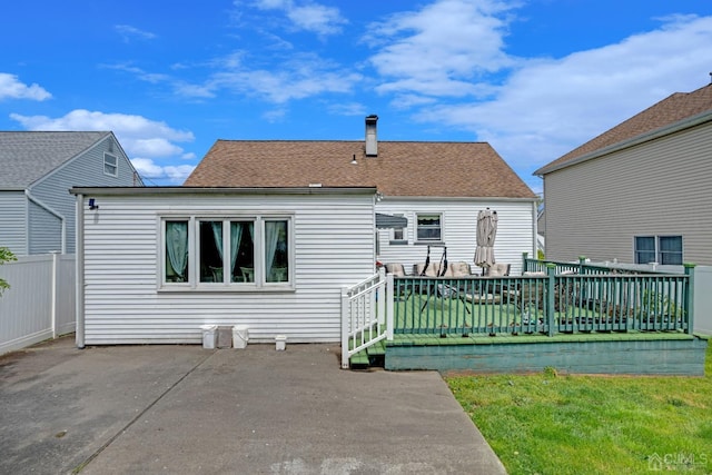 rear view of house with a lawn, a patio, and a wooden deck