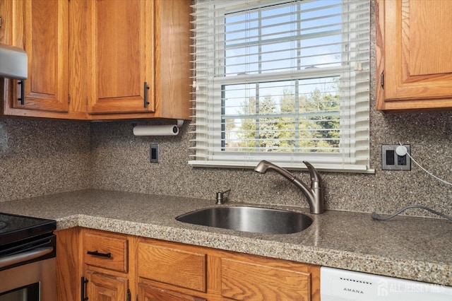 kitchen featuring white dishwasher, sink, electric range, and tasteful backsplash