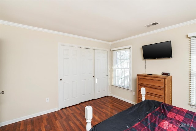 bedroom with ornamental molding, dark wood-type flooring, and a closet