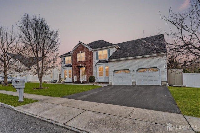 57 Cortland Dr N, East Brunswick, NJ 08816 - view of front of house featuring a lawn, fence, an attached garage, and driveway