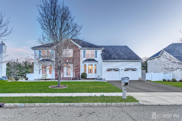 57 Cortland Dr N, East Brunswick, NJ 08816 - colonial home with aphalt driveway, fence, an attached garage, and a front yard