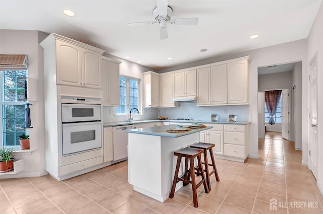 57 Cortland Dr N, East Brunswick, NJ 08816 - kitchen featuring a center island, under cabinet range hood, dishwasher, ceiling fan, and backsplash