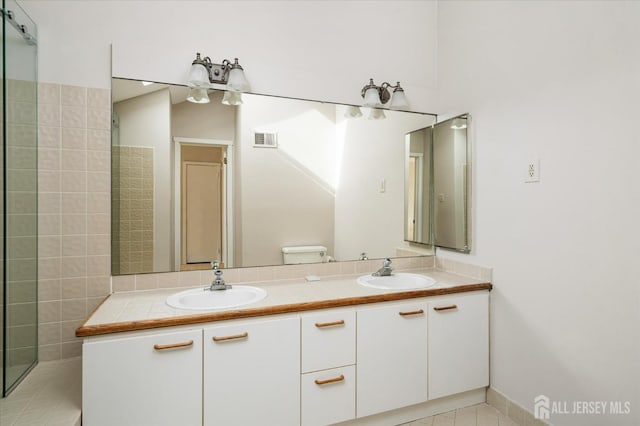 full bath featuring visible vents, a sink, toilet, and double vanity