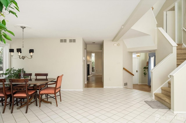 dining area with light tile patterned floors and a notable chandelier