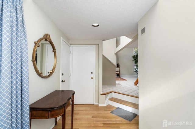 interior space with a textured ceiling and light wood-type flooring