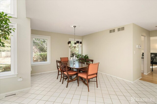 tiled dining room featuring a notable chandelier