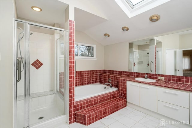 bathroom with vanity, vaulted ceiling with skylight, and plus walk in shower