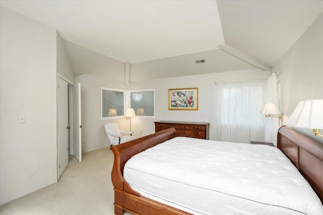 bedroom featuring lofted ceiling, visible vents, and light colored carpet