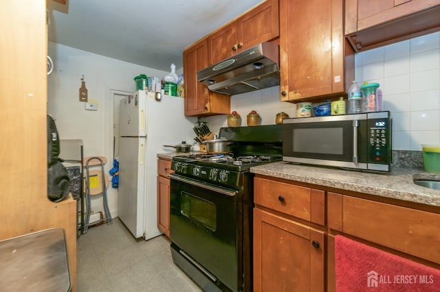 185 Redmond St, New Brunswick, NJ 08901 - kitchen featuring black range with gas cooktop, under cabinet range hood, stainless steel microwave, and tasteful backsplash
