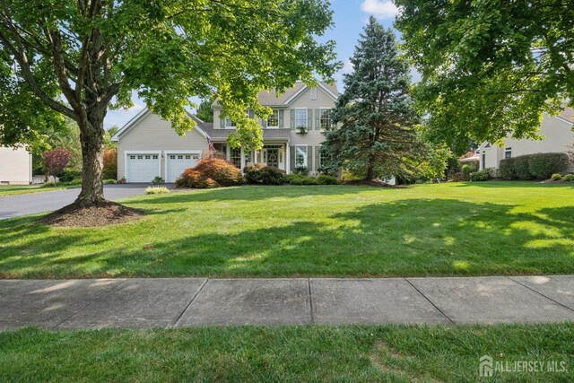 view of front of home featuring an attached garage, driveway, and a front lawn