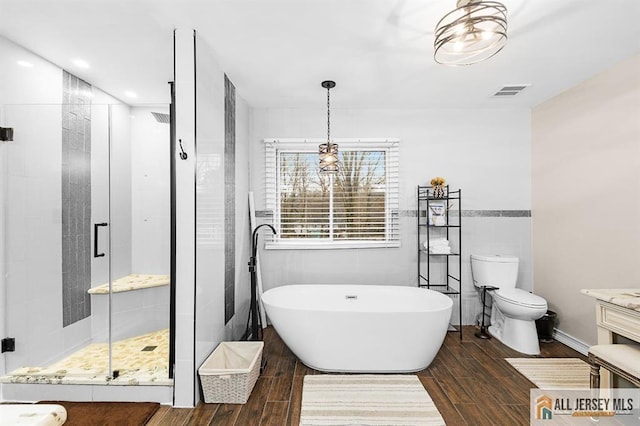 3 Eric Ct, Monroe, NJ 08831 - full bath with wood finished floors, a stall shower, a freestanding tub, tile walls, and toilet