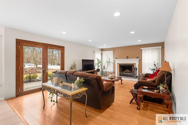 3 Eric Ct, Monroe, NJ 08831 - living room featuring french doors, light wood finished floors, recessed lighting, a fireplace with raised hearth, and baseboards