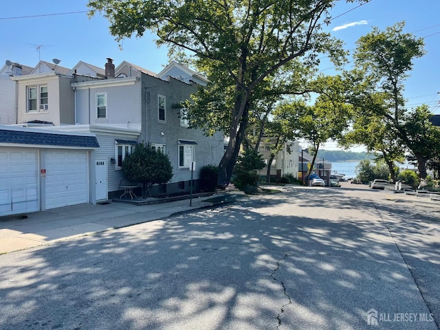 205 Water St, Perth Amboy, NJ 08861 - view of front of home featuring concrete driveway, a chimney, and stucco siding
