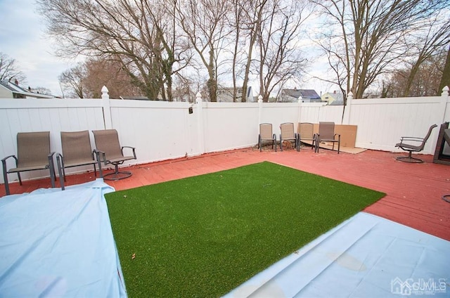 view of yard with a deck, a fenced backyard, and a patio area