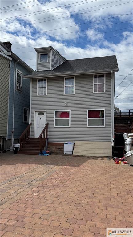 rear view of house with a patio area and cooling unit