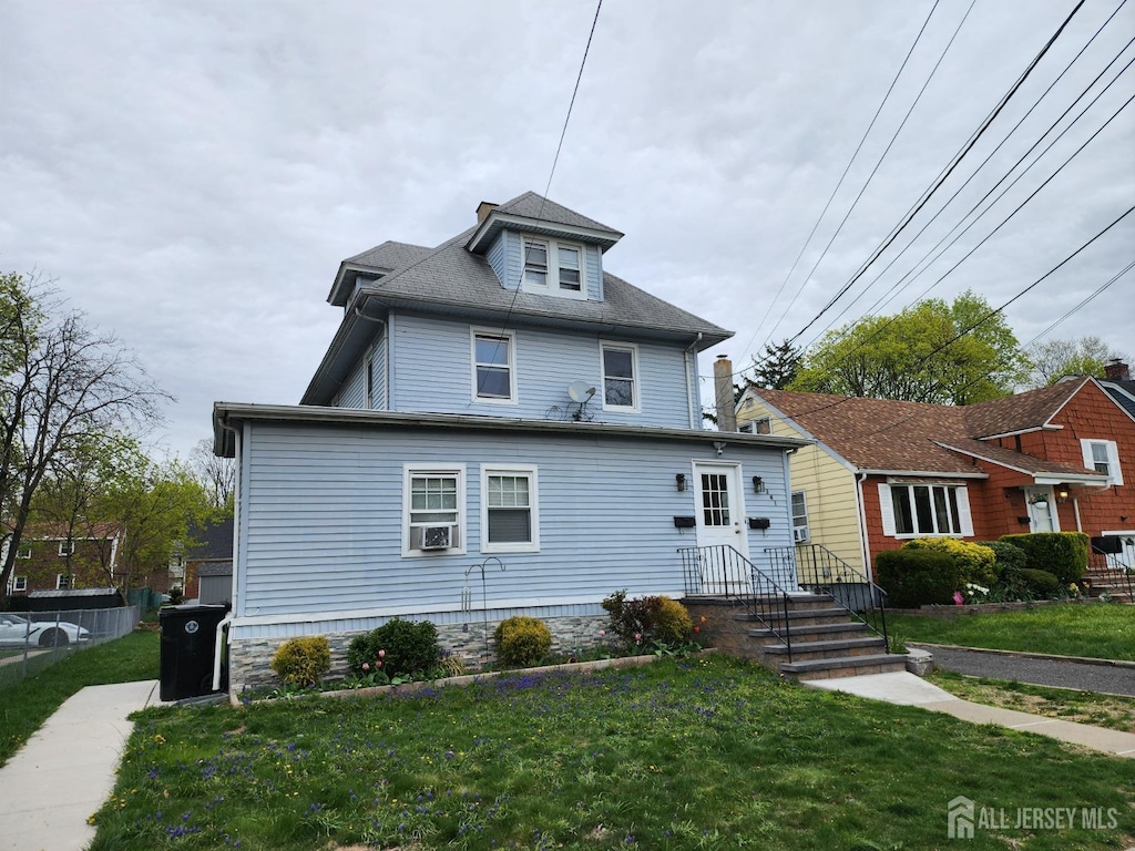 american foursquare style home featuring a front lawn and cooling unit