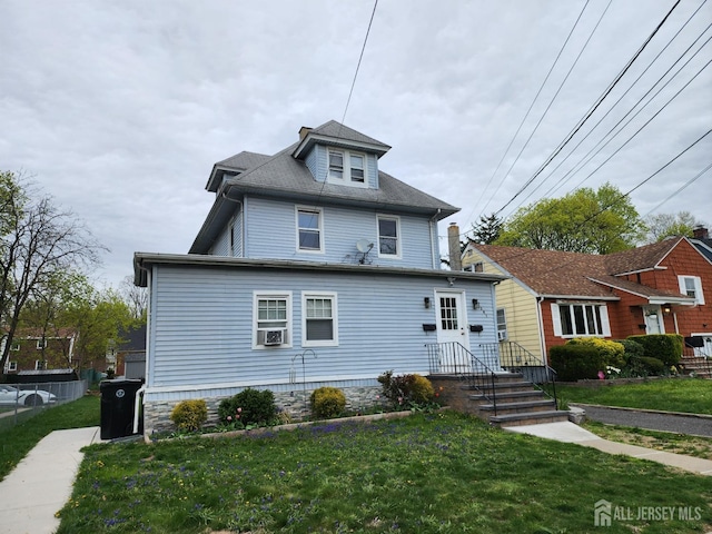 american foursquare style home featuring a front lawn and cooling unit