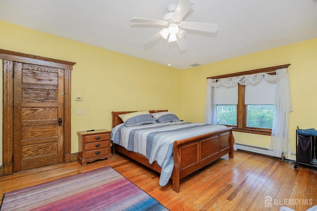 322 2nd St, Middlesex, NJ 08812 - bedroom with light wood-style floors, a baseboard heating unit, and ceiling fan