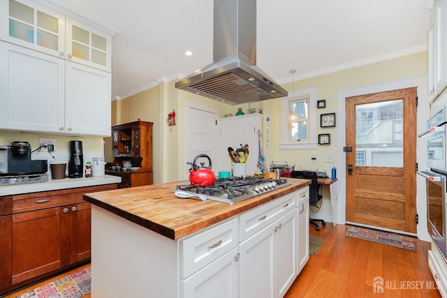 322 2nd St, Middlesex, NJ 08812 - kitchen featuring island range hood, butcher block counters, ornamental molding, light wood-style flooring, and glass insert cabinets