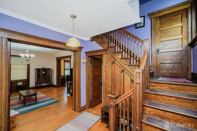 322 2nd St, Middlesex, NJ 08812 - staircase featuring wood finished floors, ornamental molding, and a chandelier