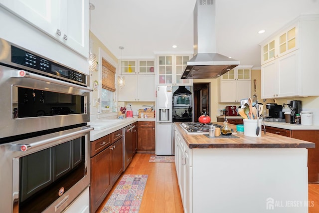 322 2nd St, Middlesex, NJ 08812 - kitchen with island range hood, a kitchen island, appliances with stainless steel finishes, light wood-style floors, and butcher block counters