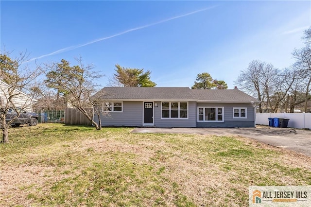 ranch-style house with a front lawn and fence