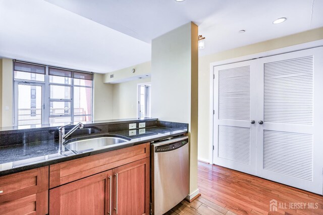 20 Livingston Ave Unit 902, New Brunswick, NJ 08901 - kitchen featuring stainless steel dishwasher, brown cabinets, light wood-style flooring, dark stone countertops, and recessed lighting