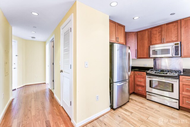 20 Livingston Ave Unit 902, New Brunswick, NJ 08901 - kitchen featuring stainless steel appliances, dark countertops, light wood finished floors, recessed lighting, and brown cabinets