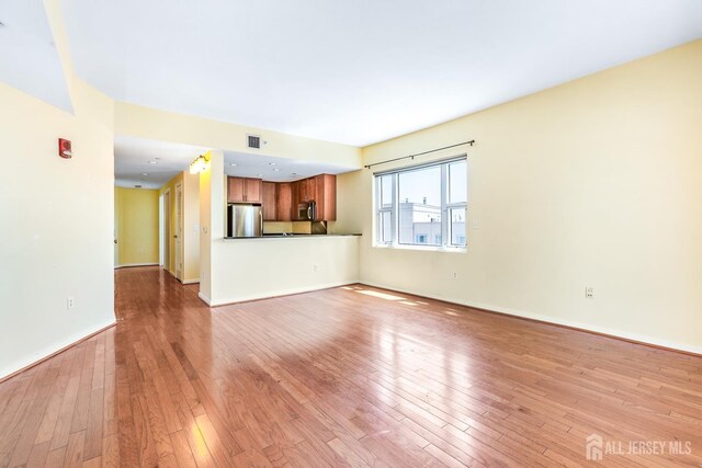 20 Livingston Ave Unit 902, New Brunswick, NJ 08901 - unfurnished living room with light wood finished floors and baseboards
